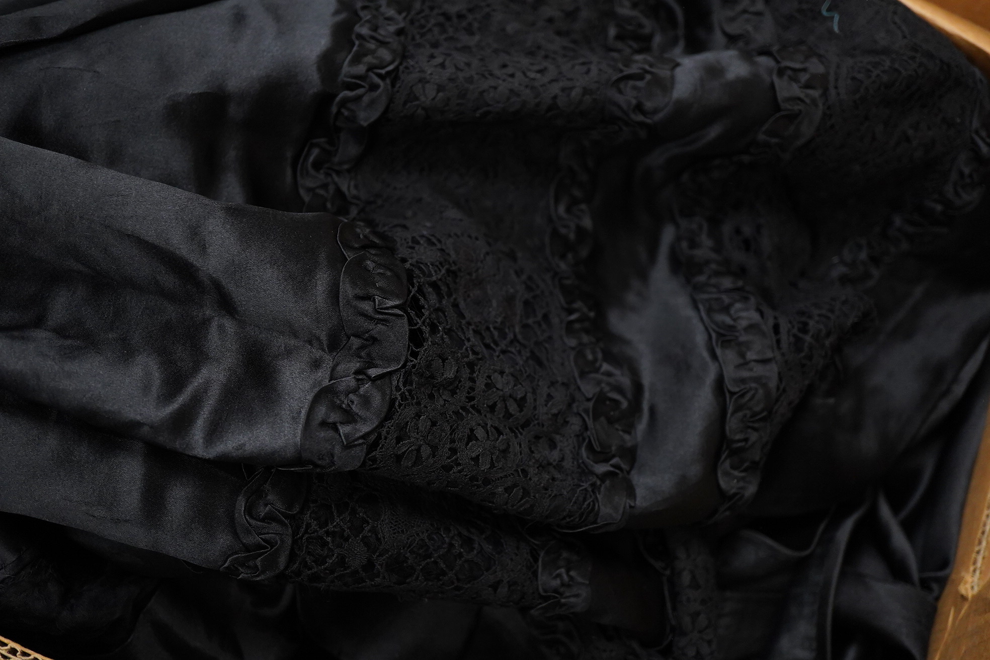 Two Edwardian blouses and three earlier lace camisoles, three black satin partly sewn skirts and later black velvet diamonte decorated evening coat. Condition - the coat, skirts and blouses need repair but are good for T